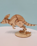 Wooden aardvark figurine on a white base with a light blue background