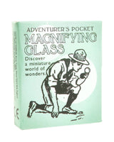 Box cover of 'Adventurer's Pocket Magnifying Glass' with illustration of a person using a magnifying glass.