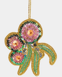 Decorative flower ornament with pink centers, green leaves, and gold accents on a white background